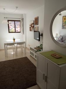 a living room with a table and a mirror at Apartamento en Port Saplaya in Port Saplaya