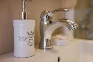 a white bottle of soap sitting on a bathroom sink at Rooms Villa Duketis in Rovinj