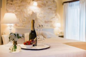 uma mesa com uma garrafa de vinho e uma taça de fruta em Rooms Villa Duketis em Rovinj