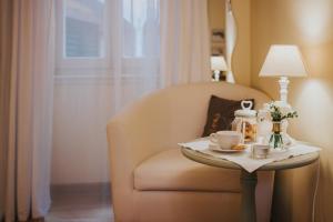 una habitación con una silla y una mesa con una lámpara en Rooms Villa Duketis, en Rovinj