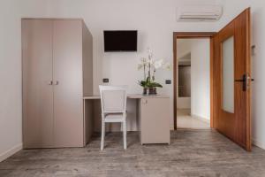 a room with a desk with a chair and a television at Affitta Camere Elena in Colà di Lazise