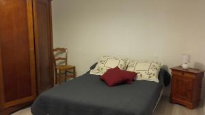 - une chambre avec un lit doté d'oreillers et d'une chaise dans l'établissement 12 Grand Sable, à Saint-Émilion