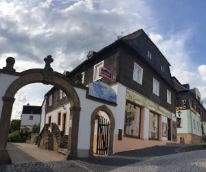 a black and white building with an arch in a street at Penzion Sklář in Nový Bor