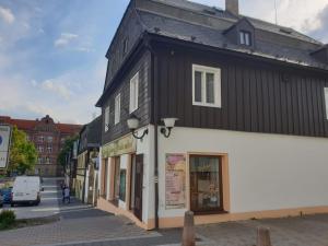 a black and white building on a city street at Penzion Sklář in Nový Bor