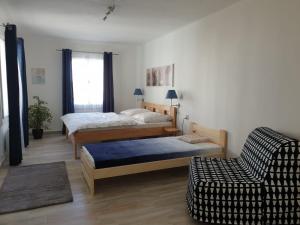 a bedroom with two beds and a couch and a chair at Penzion Sklář in Nový Bor