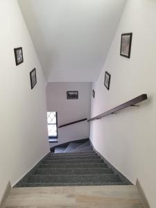a staircase in an attic with white walls and a window at Penzion Sklář in Nový Bor