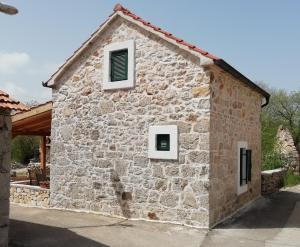 a stone building with two windows on it at Krka Waterfalls Stonehouse Roko in Lozovac