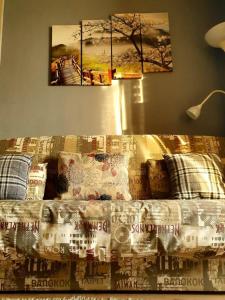 Bett in einem Zimmer mit zwei Gemälden an der Wand in der Unterkunft Dnipo river Apart #з видом на Дніпро in Dnipro