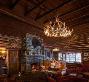 two people sitting in a living room with a fireplace at Storm Mountain Lodge & Cabins in Banff