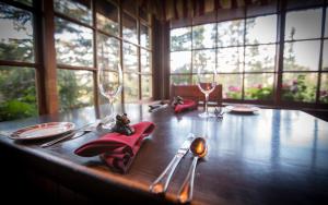 a wooden table with wine glasses and napkins on it at Storm Mountain Lodge & Cabins in Banff