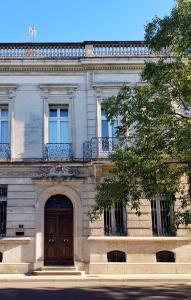 um edifício com uma porta de madeira e uma varanda em Hotel de l'Anglais, Guesthouse em Arles