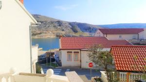 a red roofed house with a stop sign on a street at Apartments Niko Metajna, island Pag in Metajna