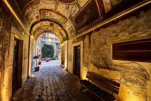 einen leeren Flur mit einer Bank in einem Gebäude in der Unterkunft Residenze Gregoriane - Residenza d'Epoca in Tivoli