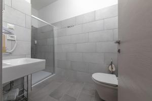 a white bathroom with a toilet and a sink at La Preziosa Rooms in Pula