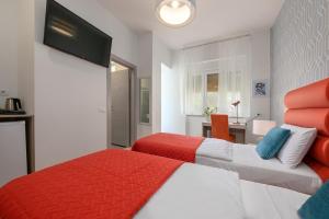 a hotel room with two beds and a desk at La Preziosa Rooms in Pula
