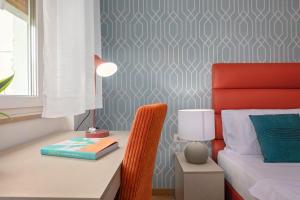 a bedroom with a bed and a desk with a lamp at La Preziosa Rooms in Pula