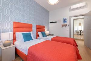 two beds in a bedroom with red and white at La Preziosa Rooms in Pula