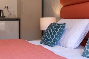 a bedroom with a bed with blue and white pillows at La Preziosa Rooms in Pula