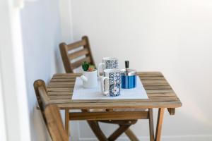 a wooden table with mugs and plants on it at La Preziosa Rooms in Pula