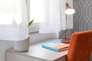 a table with a lamp and two books on it at La Preziosa Rooms in Pula