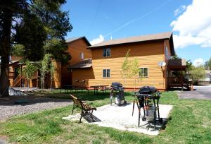 un parco con due panchine e un grill di fronte a un edificio di The Aspen a West Yellowstone