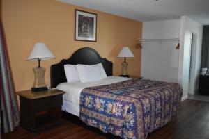 a bedroom with a bed and two lamps on a table at Valley Hotel in Rosemead