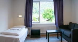 a hotel room with a bed and a couch and a window at Sogndal Bed & Breakfast in Sogndal