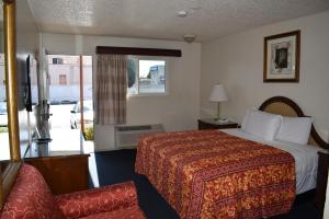 a hotel room with a bed and a chair at Valley Hotel in Rosemead
