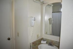 a bathroom with a hair dryer next to a sink at Valley Hotel in Rosemead +37 photos