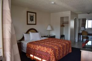 a hotel room with a bed with a red blanket at Valley Hotel in Rosemead