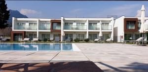 un hotel con piscina, sillas y un edificio en Piamarta Apartments, en Toscolano Maderno