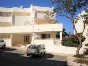 a car parked in front of a white building at Belinha Guest House in Luz