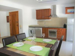 a kitchen with a table with plates and wine glasses at Belinha Guest House in Luz