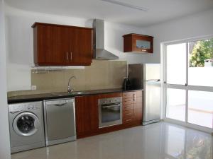 a kitchen with a washer and a sink and a dishwasher at Belinha Guest House in Luz +16 photos