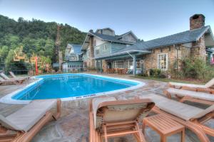 a swimming pool with chairs and a house at Gatlinburg Inn in Gatlinburg