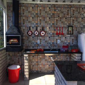 a kitchen with a brick wall with a stove at Amsterdam lofts 2 in Poços de Caldas