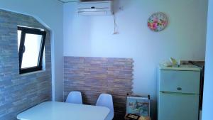 a kitchen with a white table and a refrigerator at Apartments Niko Metajna, island Pag in Metajna