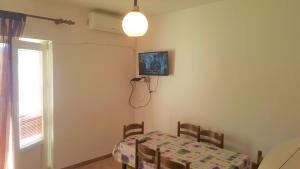 a table and chairs in a room with a table and a window at Apartments Niko Metajna, island Pag in Metajna