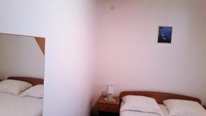 a bedroom with two beds and a mirror at Apartments Niko Metajna, island Pag in Metajna