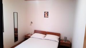 a bedroom with a bed with two night stands and a mirror at Apartments Niko Metajna, island Pag in Metajna