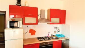 a kitchen with red cabinets and a white refrigerator at Apartments Niko Metajna, island Pag in Metajna