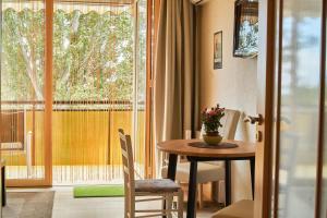 a dining room with a table and a large window at seeYOU apartment Balatonfüred in Balatonfüred