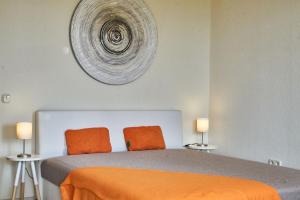 een slaapkamer met een bed met oranje lakens en 2 lampen bij seeYOU apartment Balatonfüred in Balatonfüred