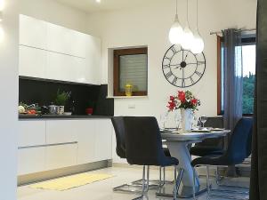 a kitchen with a table and chairs and a clock at Villa Lucija Cilipi in Čilipi