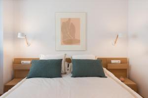 um quarto com uma cama com duas almofadas verdes em Sitges Centre. Simply Charming em Sitges