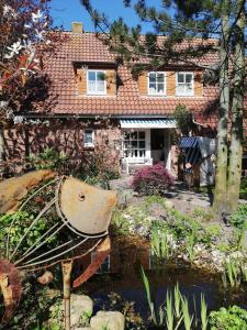 une maison avec un jardin en face dans l'établissement Hotel Garni Friesenhuus, à Greetsiel