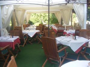 a restaurant with tables and chairs with white tablecloths at Hôtel Auberge de La Nauze in Sagelat
