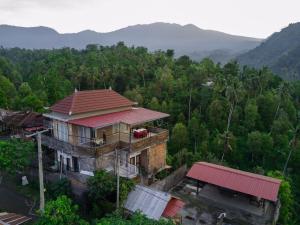 una casa vieja con techo rojo en un bosque en Sekumpul BnB, en Singaraja