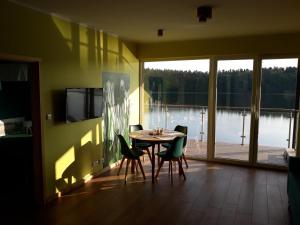 a dining room with a table and chairs and a large window at Mazurskie Klimaty Tatarak in Olsztyn