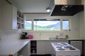 een witte keuken met een fornuis en een raam bij Sogndal Bed & Breakfast in Sogndal